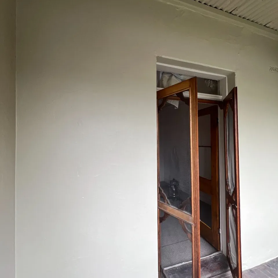 Another wall on the same verandah, beside the timber screen door, flat and freshly painted